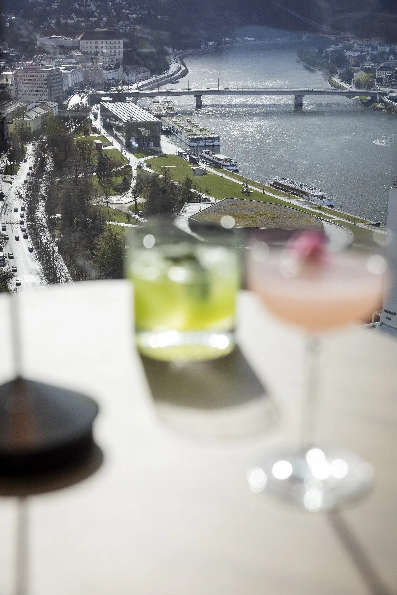 Zwei Cocktails mit Blick auf die Stadt und den Fluss im Restaurant Q27