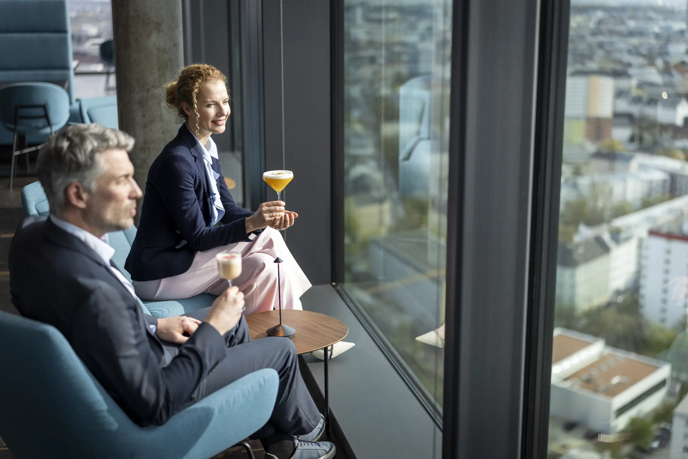 Zwei Cocktails in stilvollem Ambiente mit Blick auf die Stadt.