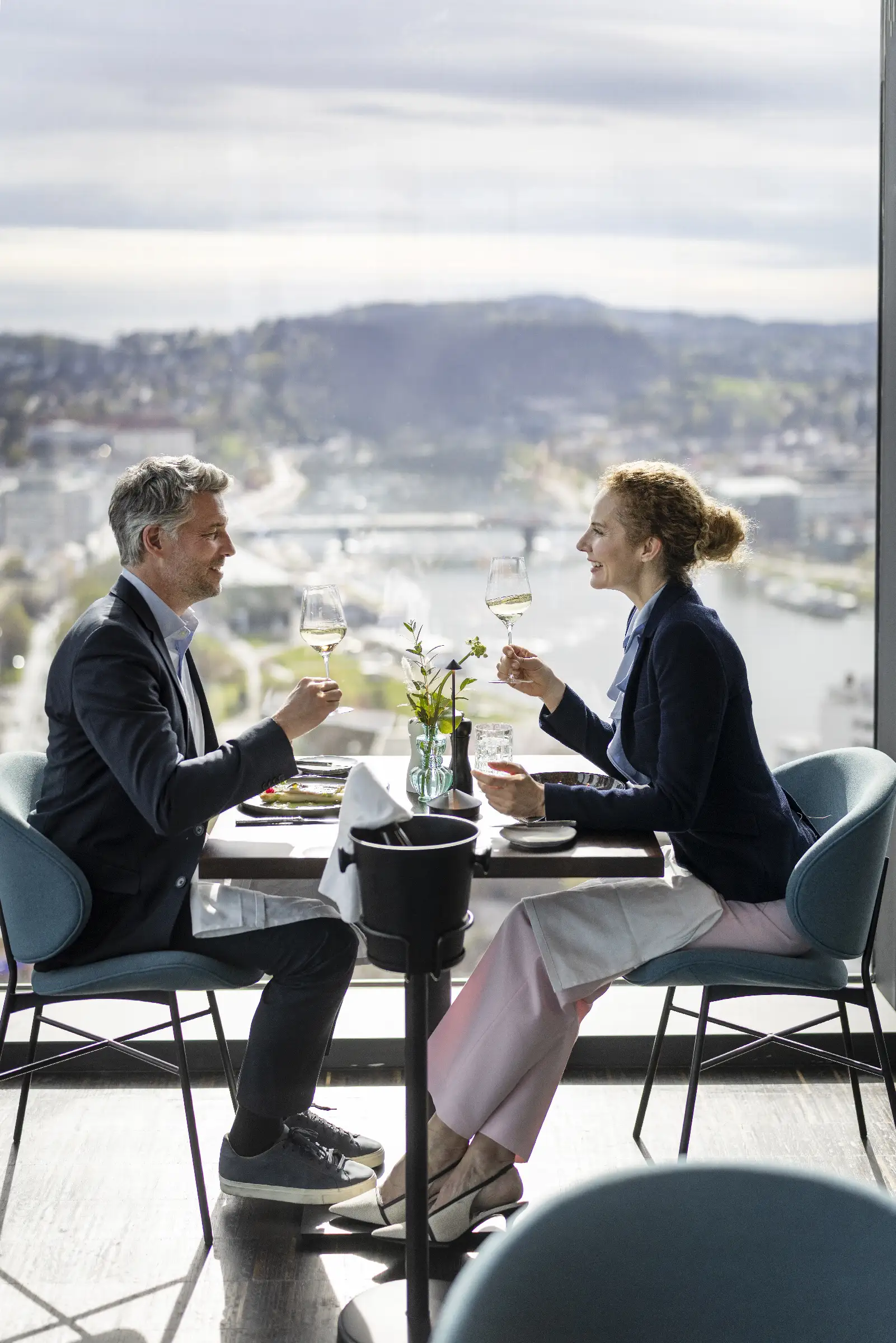Paar stößt mit Gläsern an und genießt die Aussicht im Restaurant Q27.
