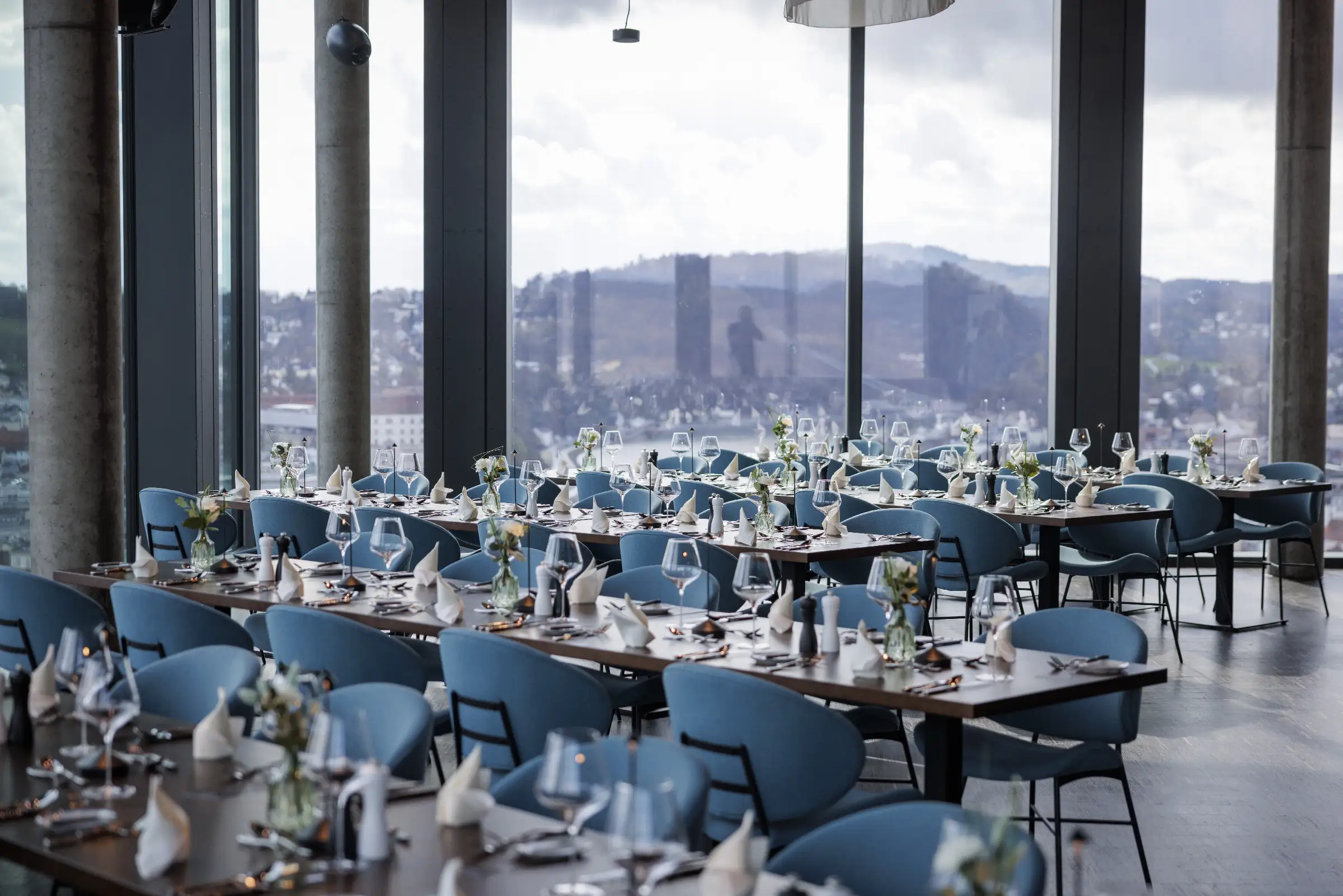 Elegante Restaurantatmosphäre mit gedeckten Tischen und Blick auf die Stadt.