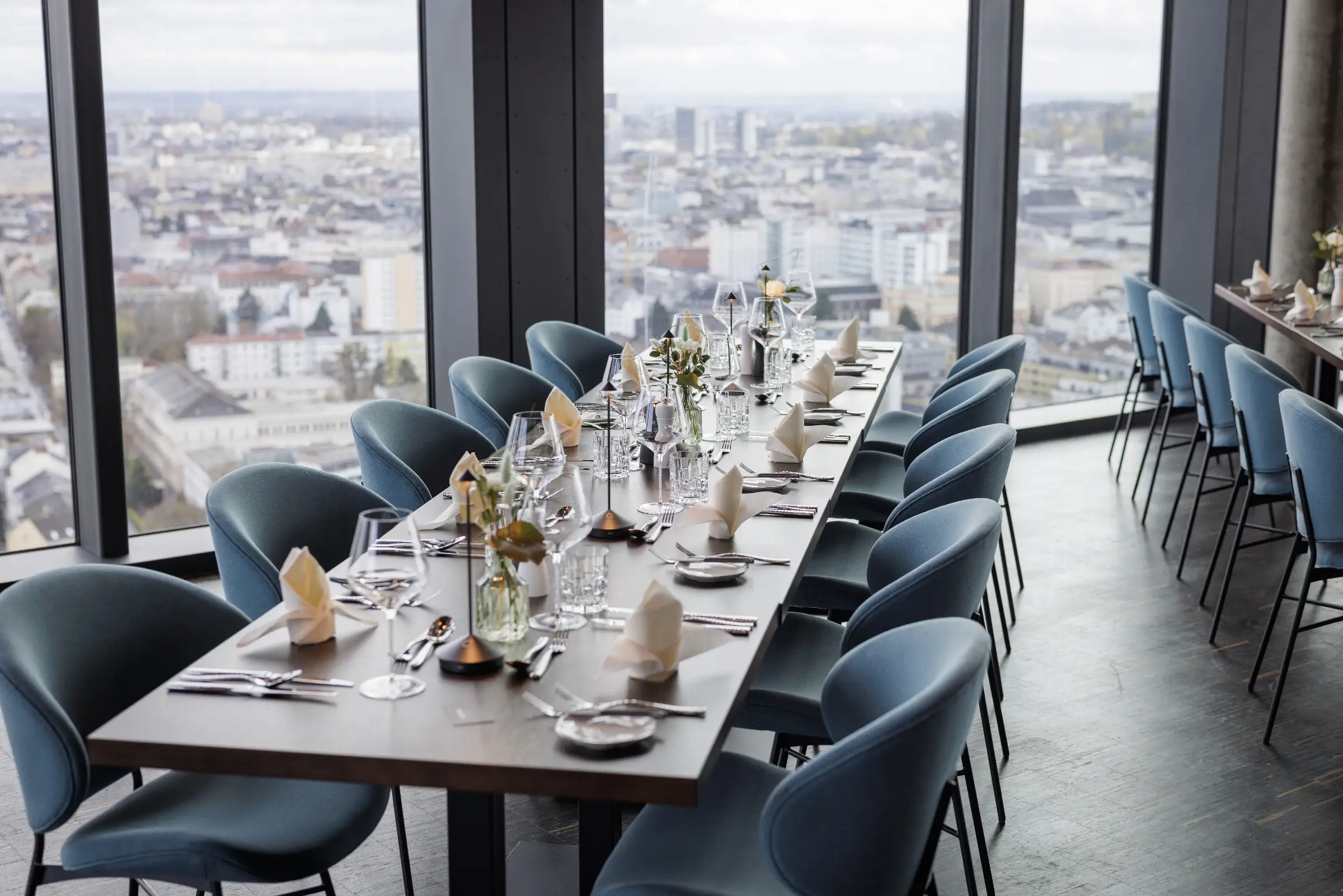 Eleganter Restaurantbereich mit gedecktem Tisch und Blick auf die Stadt.