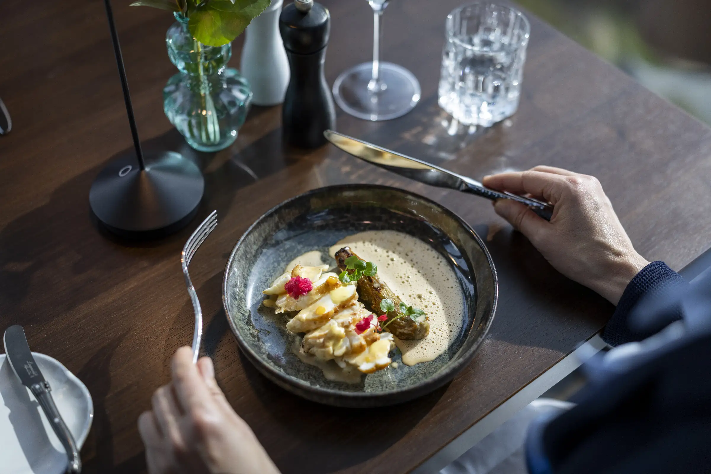 Zartes Hühnchenfilet mit cremiger Sauce und frischen Kräutern auf einem eleganten Teller im Restaurant