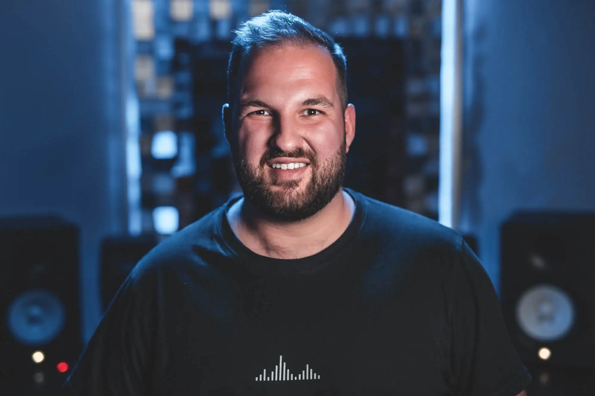Portrait eines Künstlers im Tonstudio mit moderner Technik im Hintergrund.