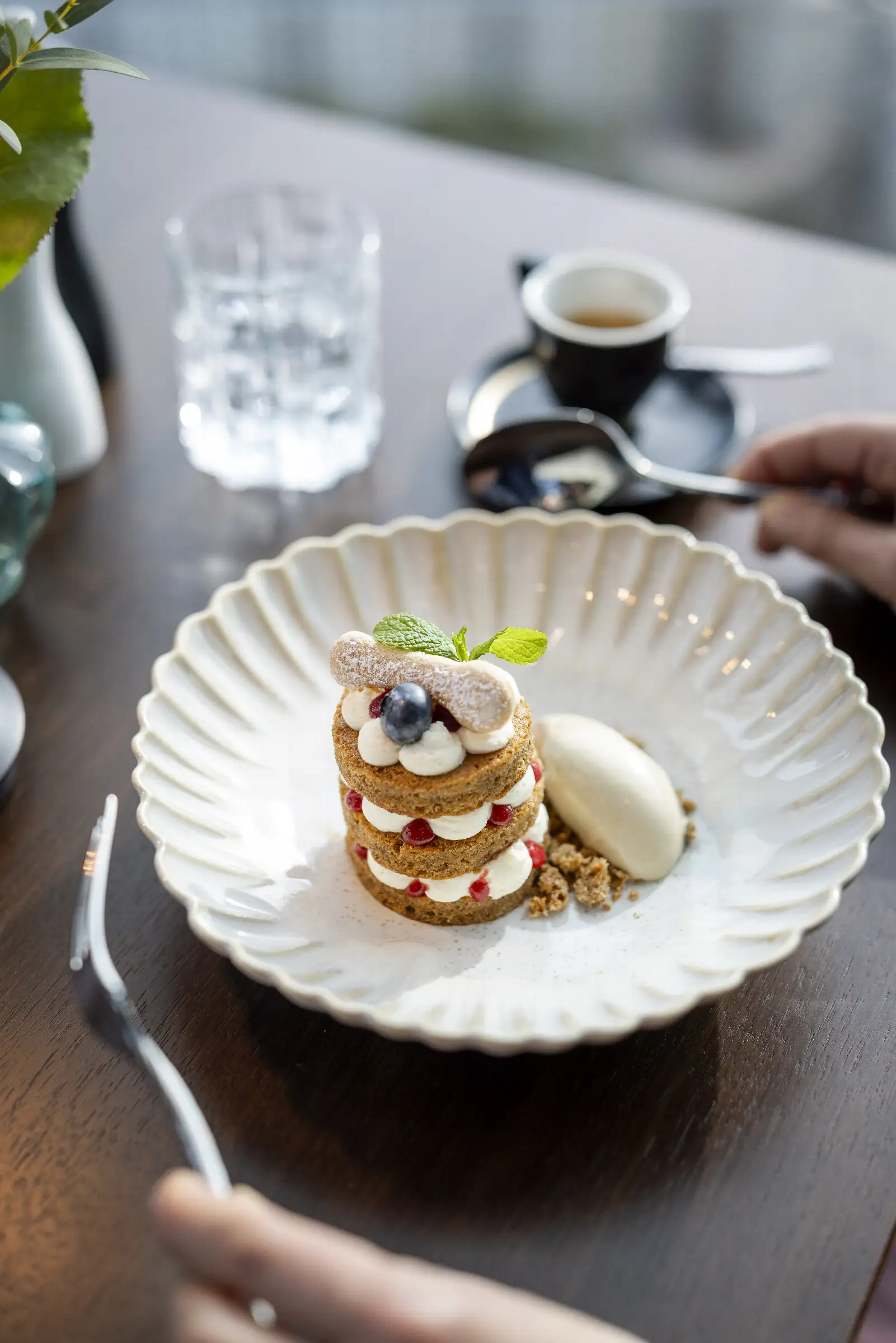 Schichtdessert mit Beeren, Sahne und Eis auf einem Teller im Restaurant