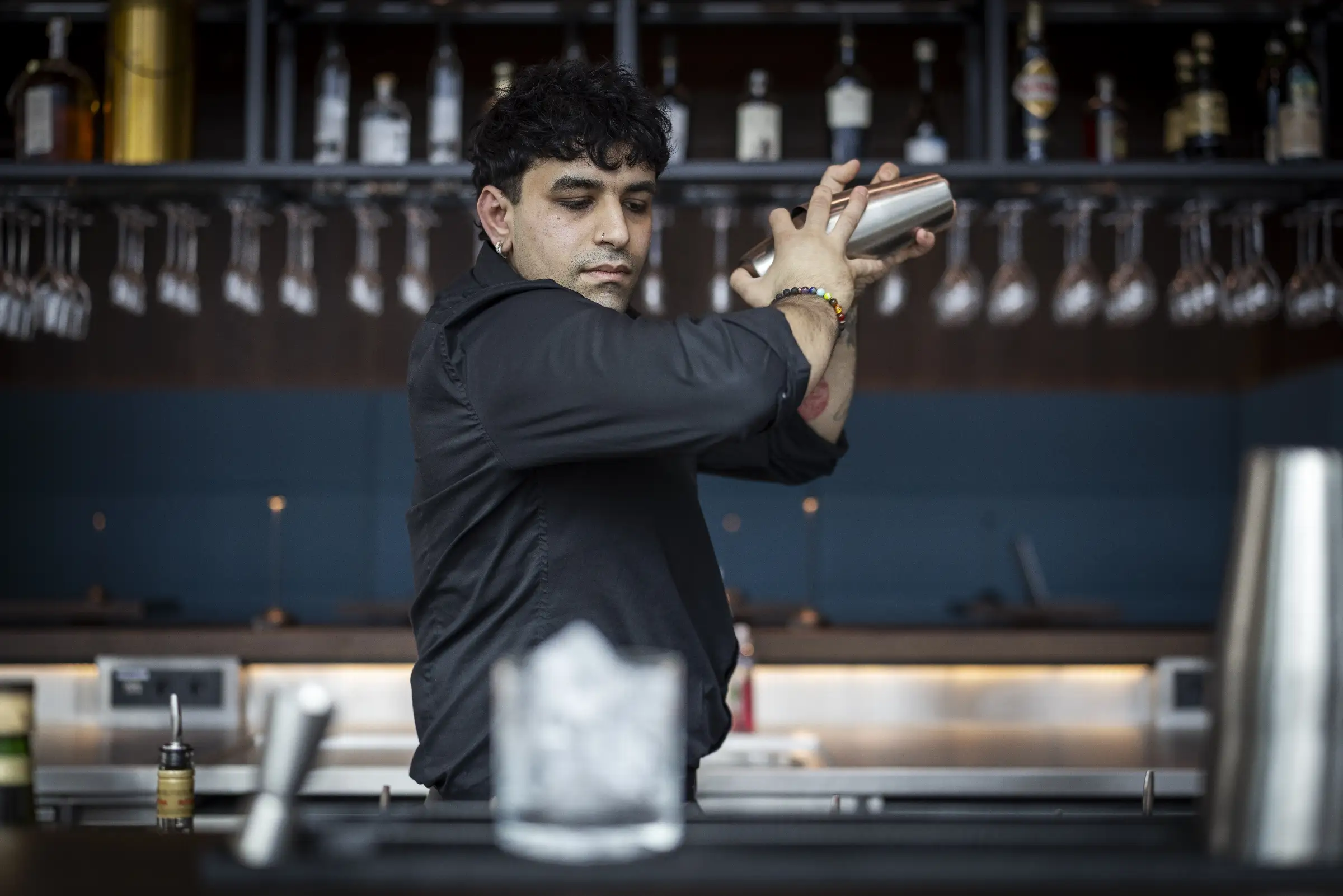 Barkeeper schüttelt einen Cocktail hinter der Bar im Restaurant Q27.
